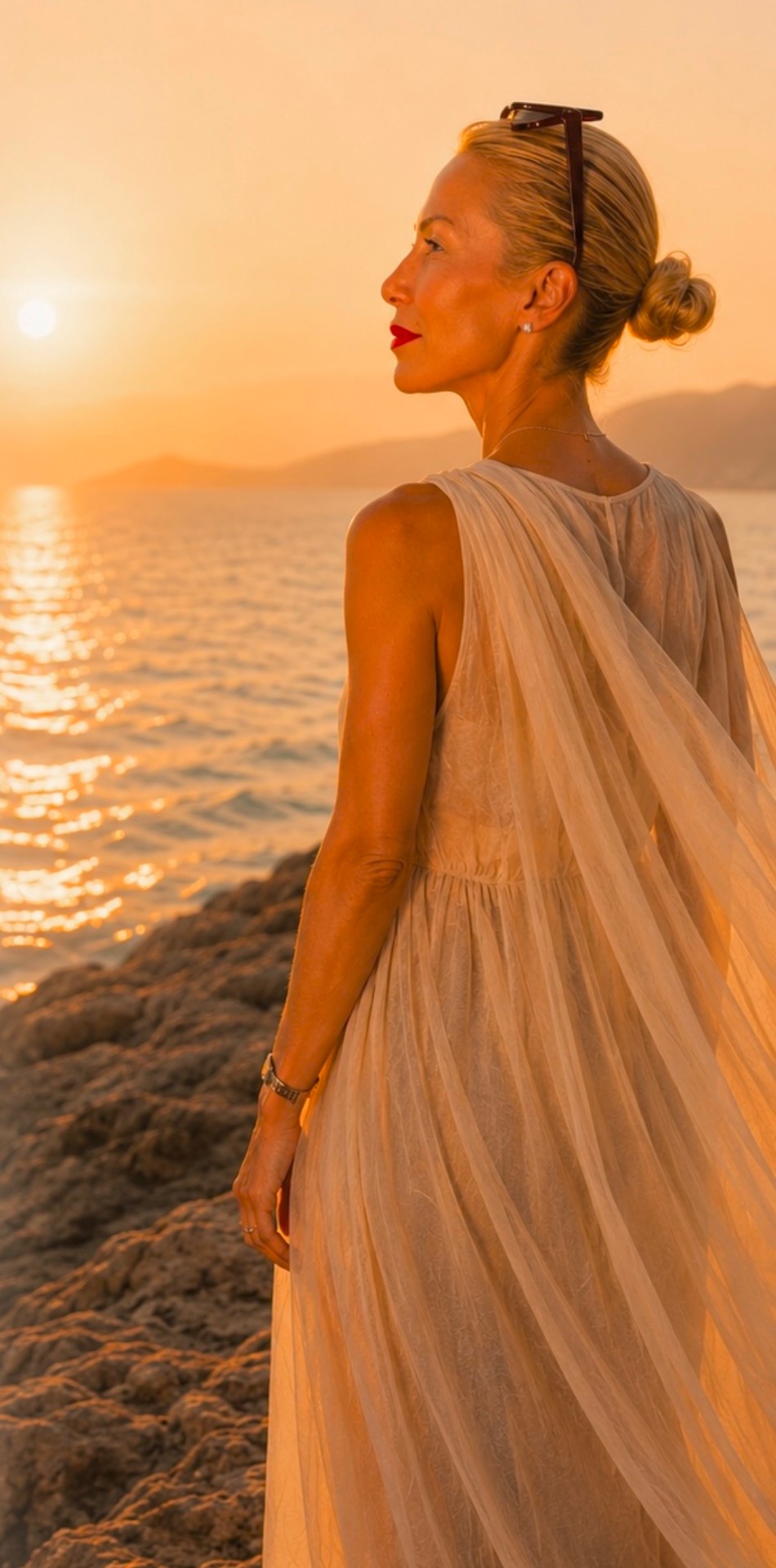 Femme blonde en robe blanche, vue de profil, coiffée en chignon, au coucher du soleil sur la plage.
Jelica Stanojlovic, Women Mentor, Sheja Journal.